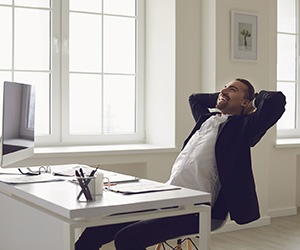 Man relaxing comfortably at his desk